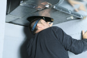 A home inspector checking a vent