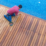 A home inspector inspecting a backyard inground swimming pool