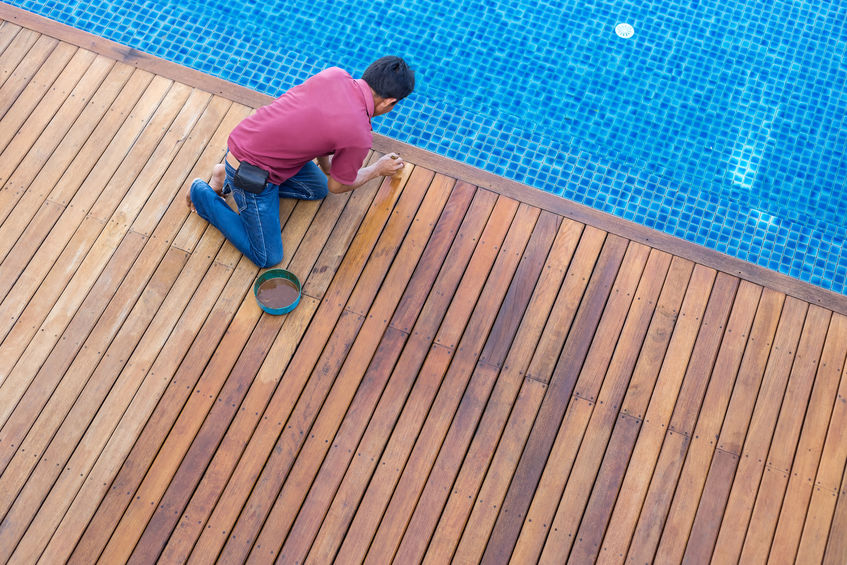 A home inspector inspecting a backyard inground swimming pool