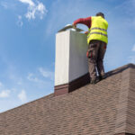 Man performing chimney inspection on a home