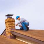 Chimney inspector on roof and looking at the exterior of the chimney