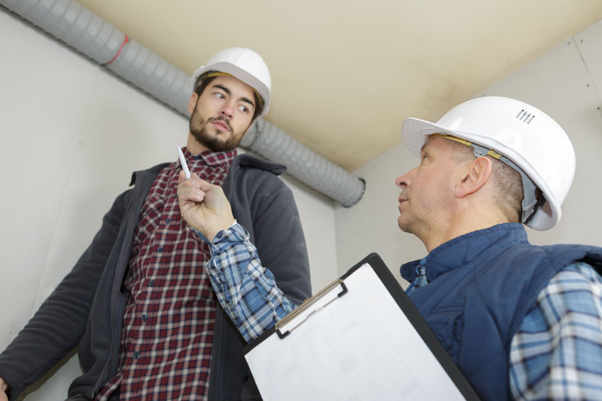 Home inspector looking at plumbing pipes