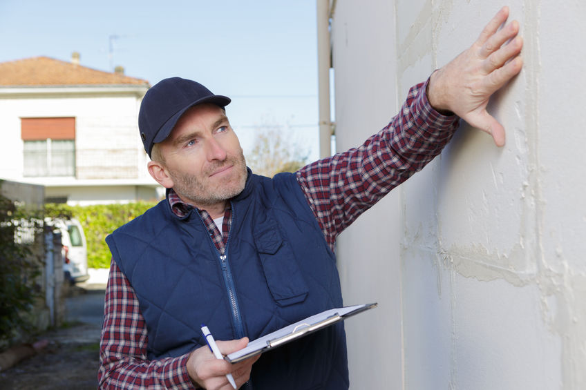 A home inspector looking at a home's foundation